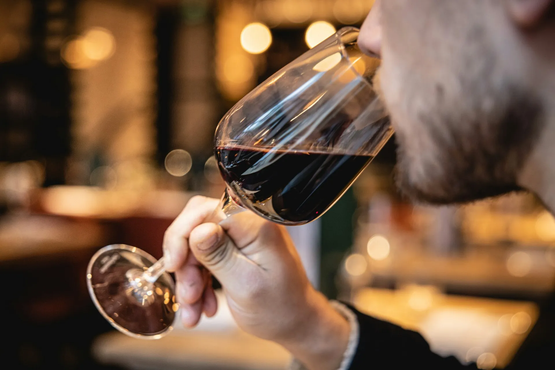 En mand dufter til et glas rødvin