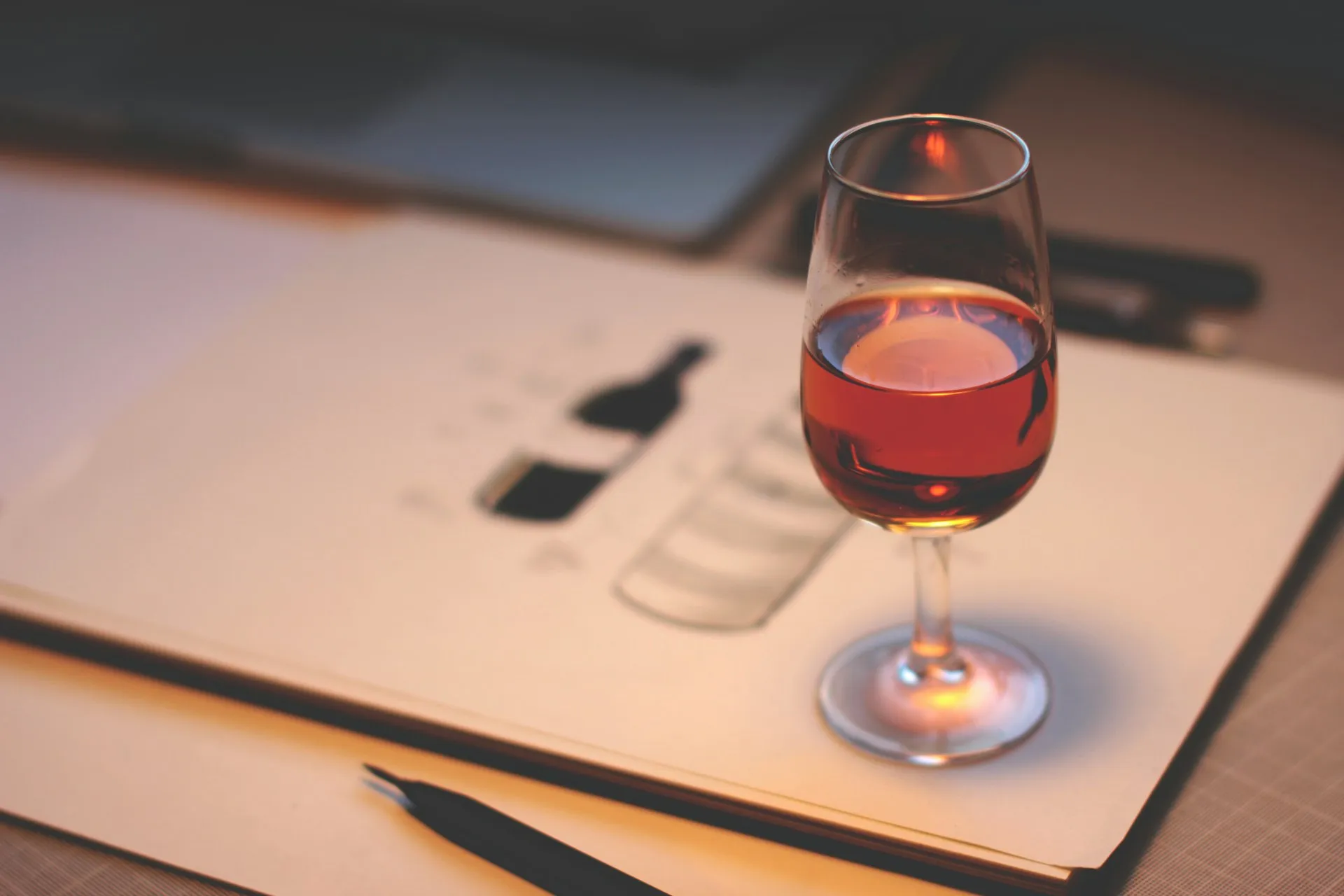 Et glas vin ved siden af en notesblok